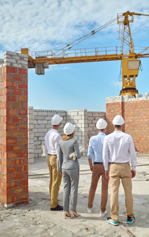 four-people-protective-helmets-inspecting-building-area four-people-protective-helmets-inspecting-building-area